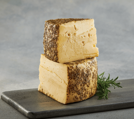 Two Wedges of Asiago Cheese stacked.